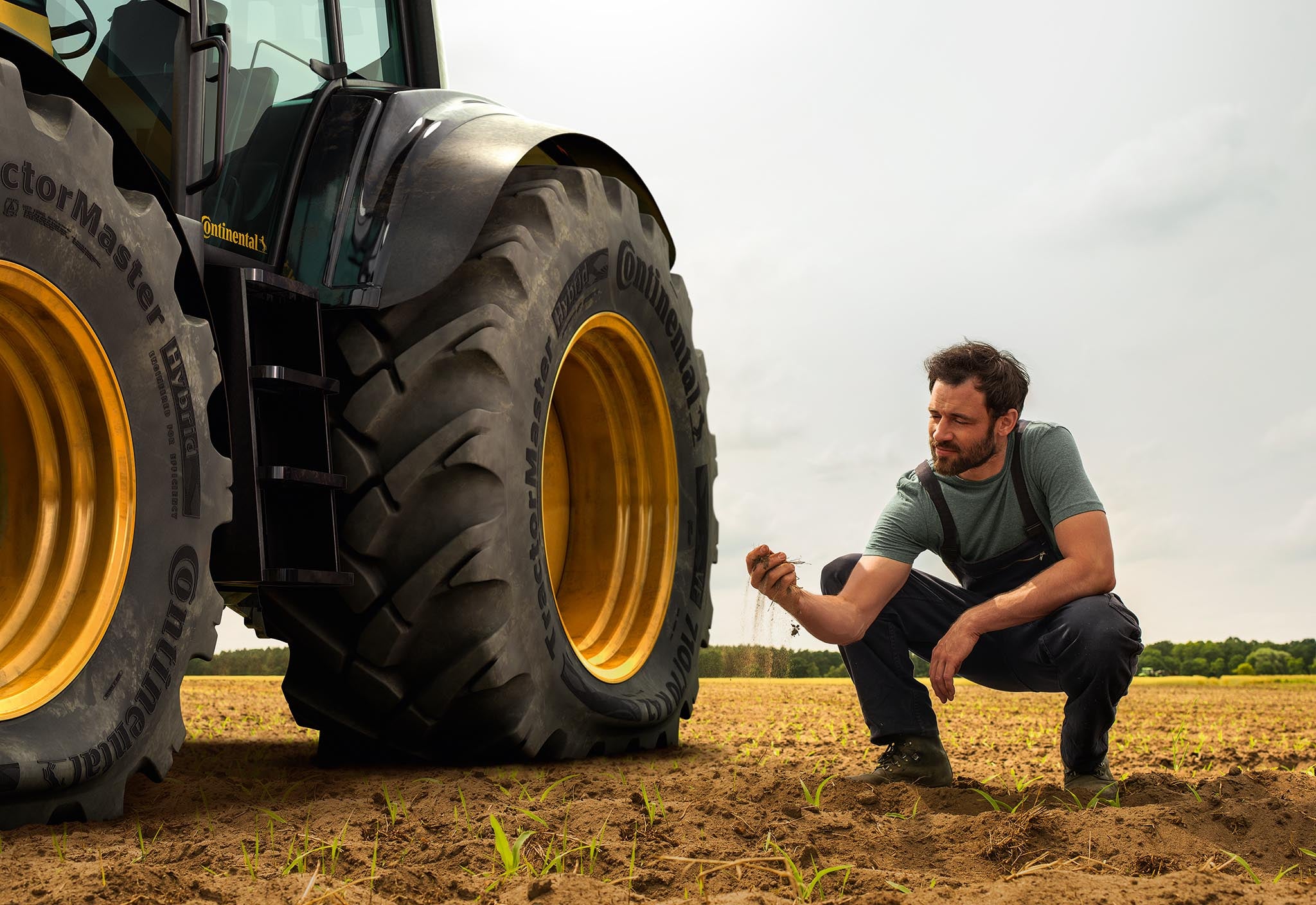 Tractor standing on farmland next to a man 