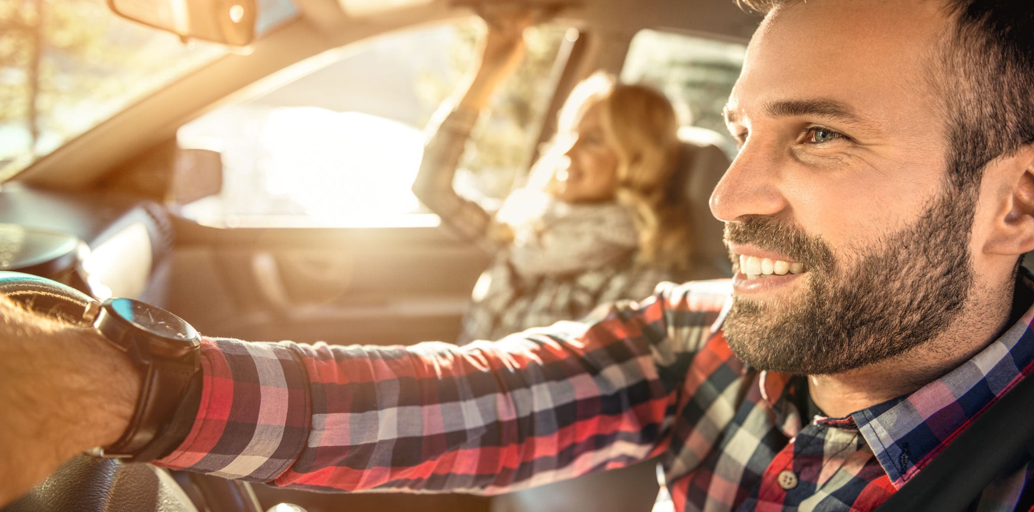 Happy couple in the car traveling together,