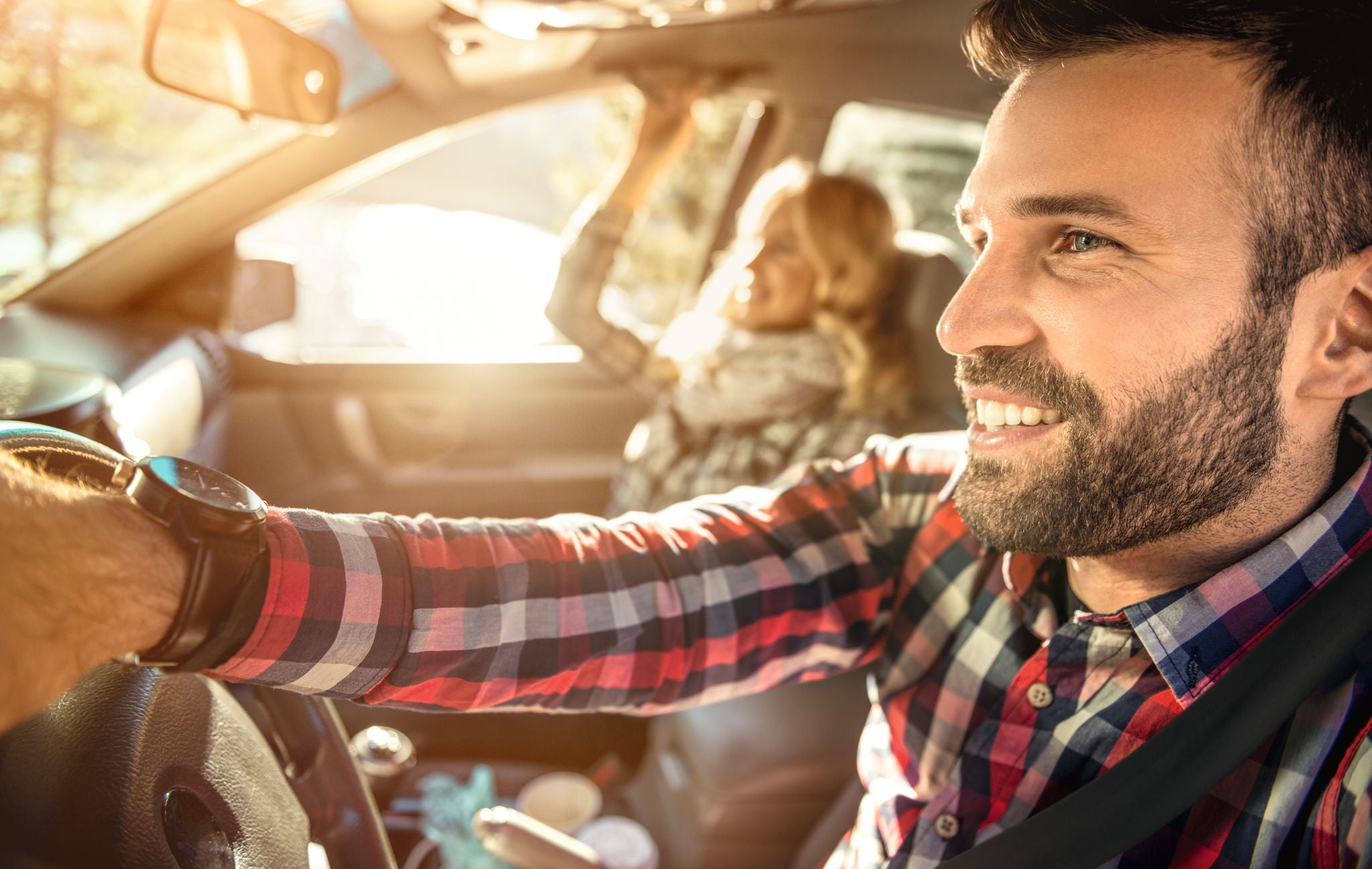 Happy couple in the car traveling together,