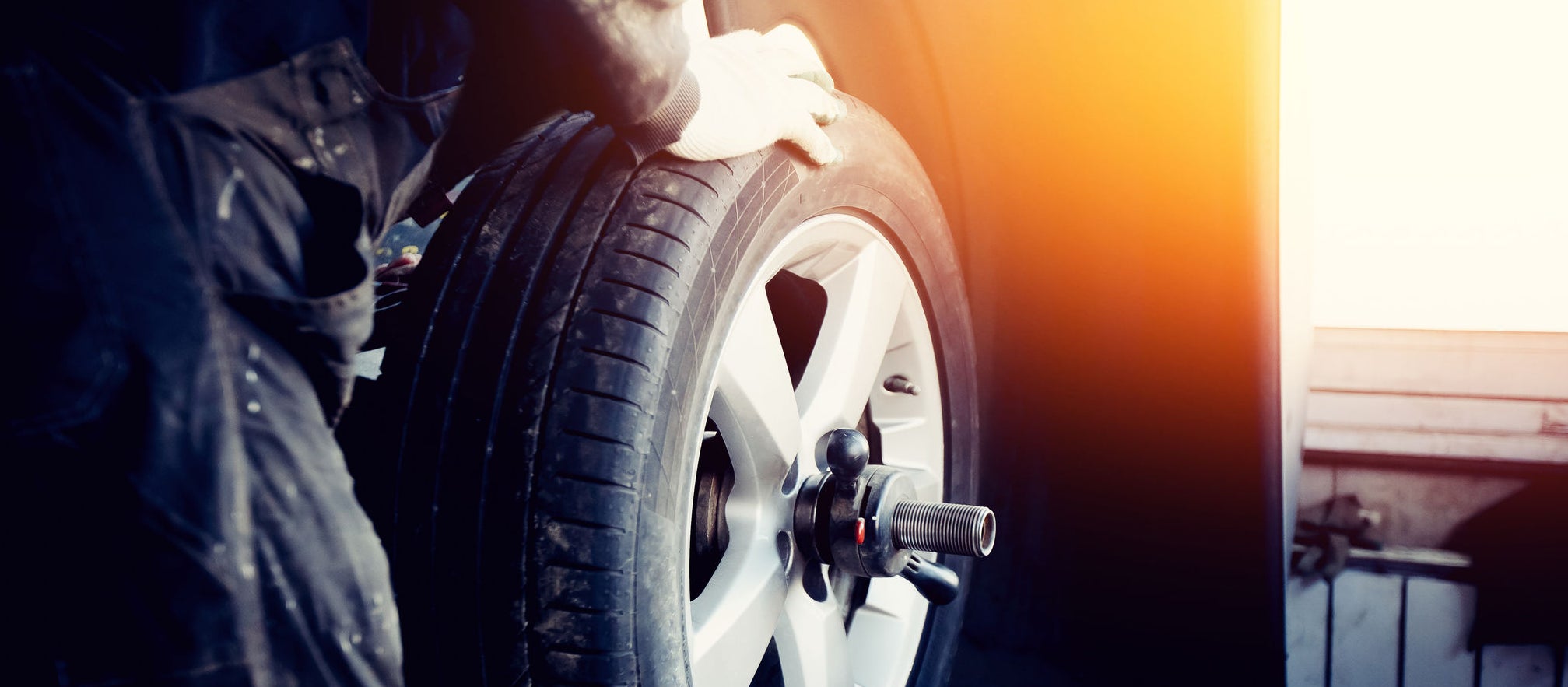 repairman balances the wheel and installs the tubeless tire of the car on the balancer in the workshop.