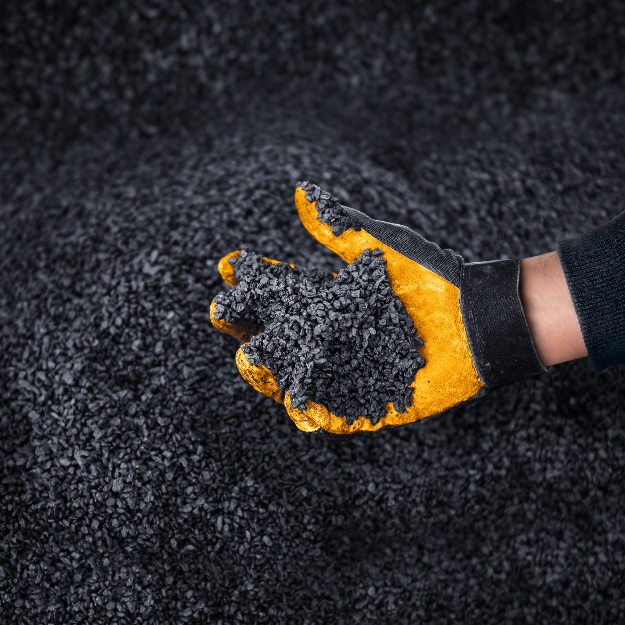 Close-up of a hand with special gloves reaching into tyre remnants