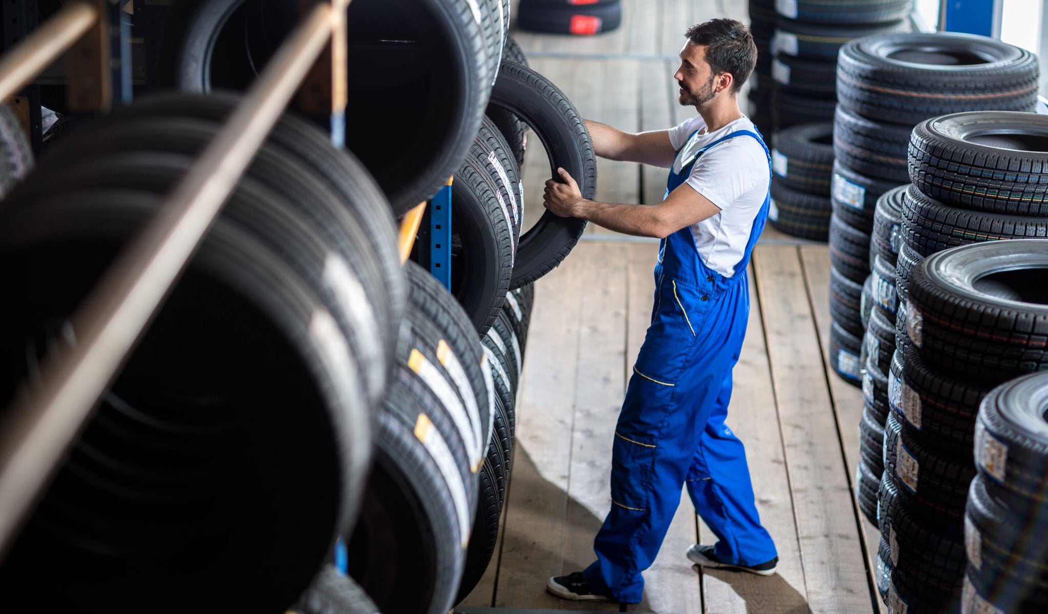 Auto mechanic  choose tire for car at a tire store