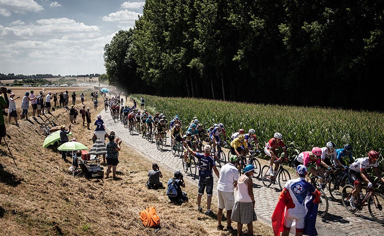 Supporters cheer riders at the cobblestone sector