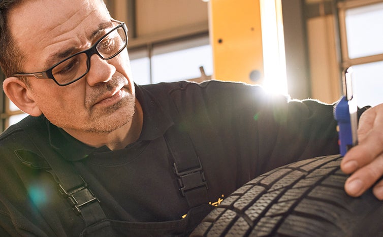 Repairman checking the tire tread.