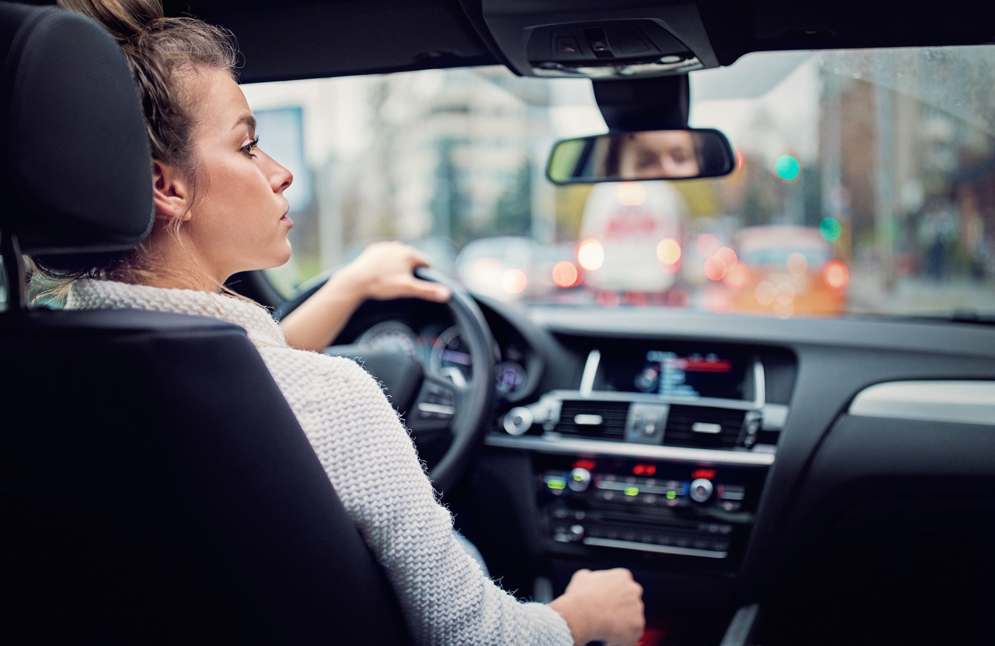 Young woman is waiting in a traffic jam in rainy day