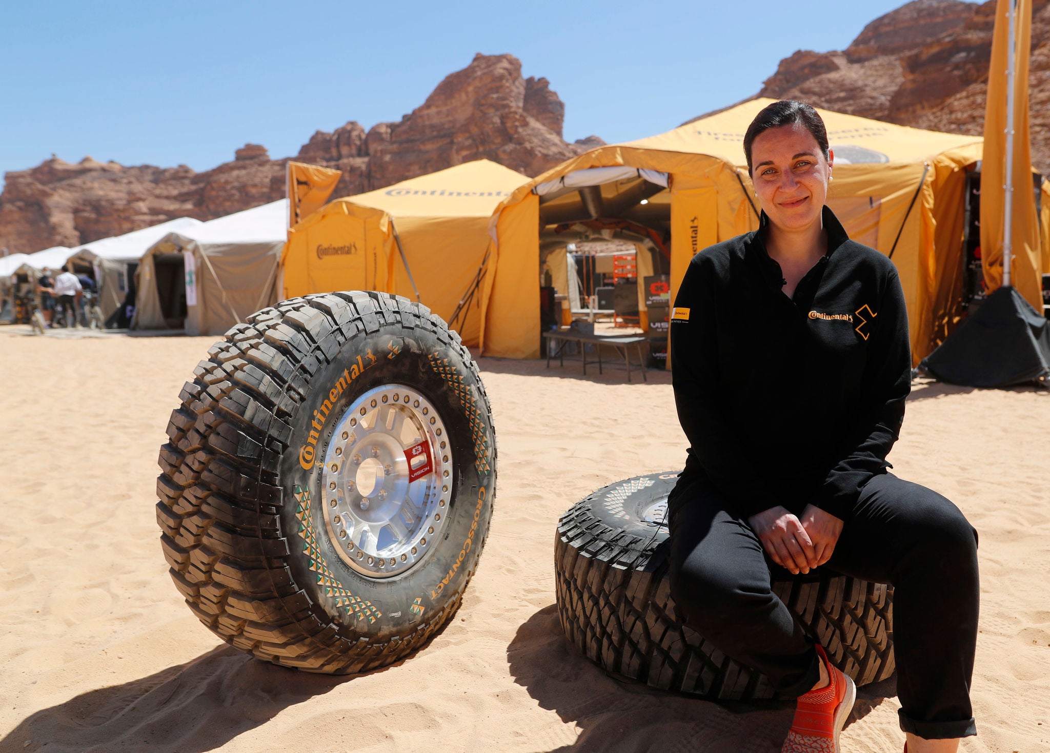 Catarina Silva assise avec les pneus de course Continental Extreme E sur le lieu de la première course : Al Ula, Arabie Saoudite