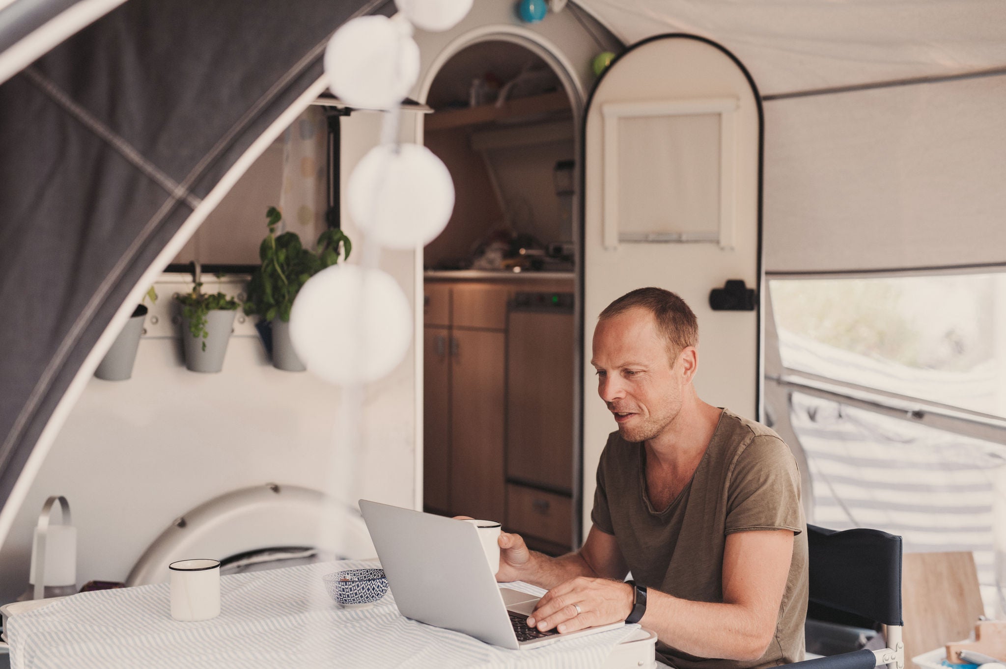 Man camping in his caravan in Europe Croatia
Photo taken outdoors in summer in natural light
Caravan trailer camper. Mna working on his computer/laptop.