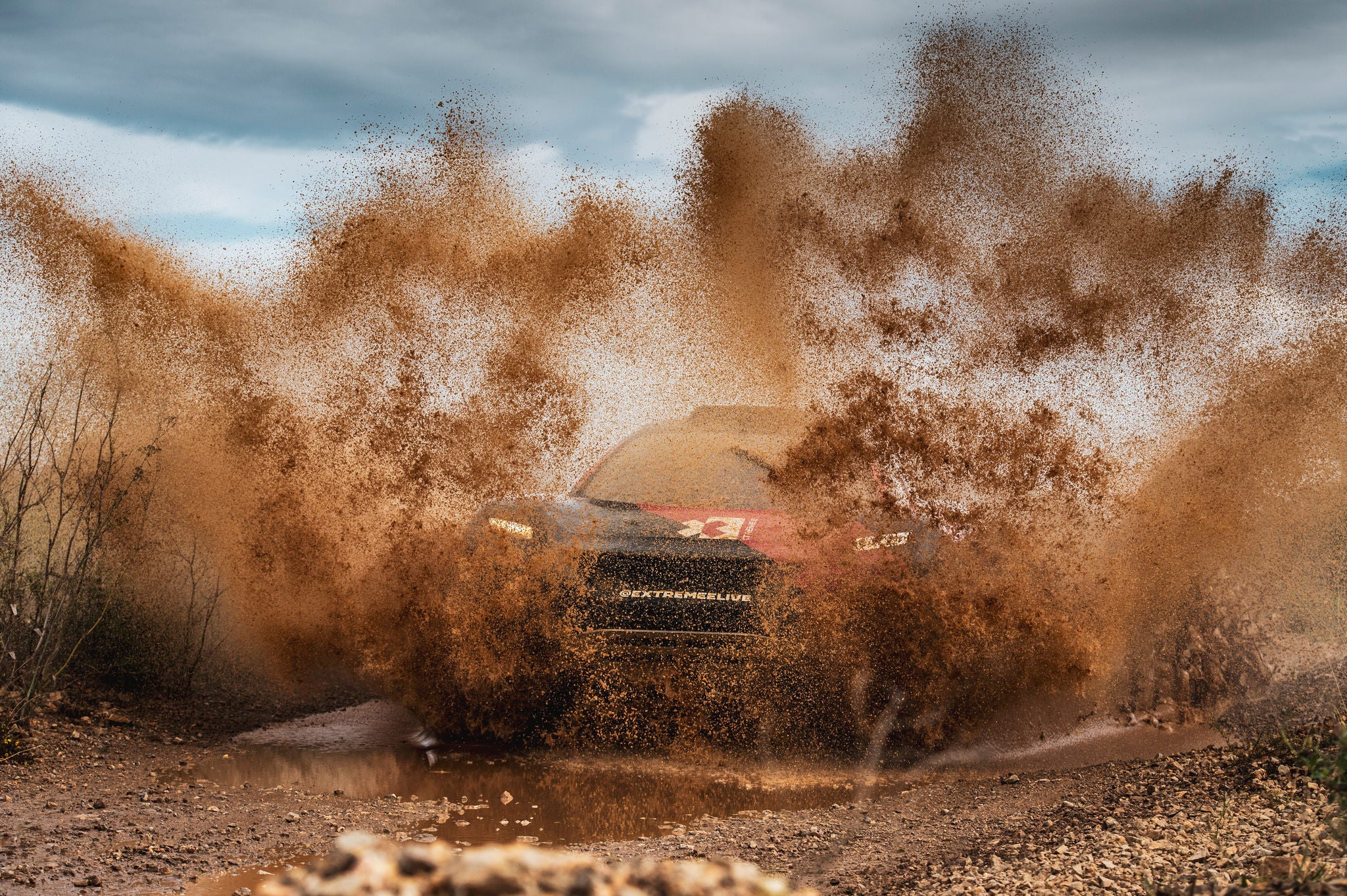 Extreme E race car driving through mud