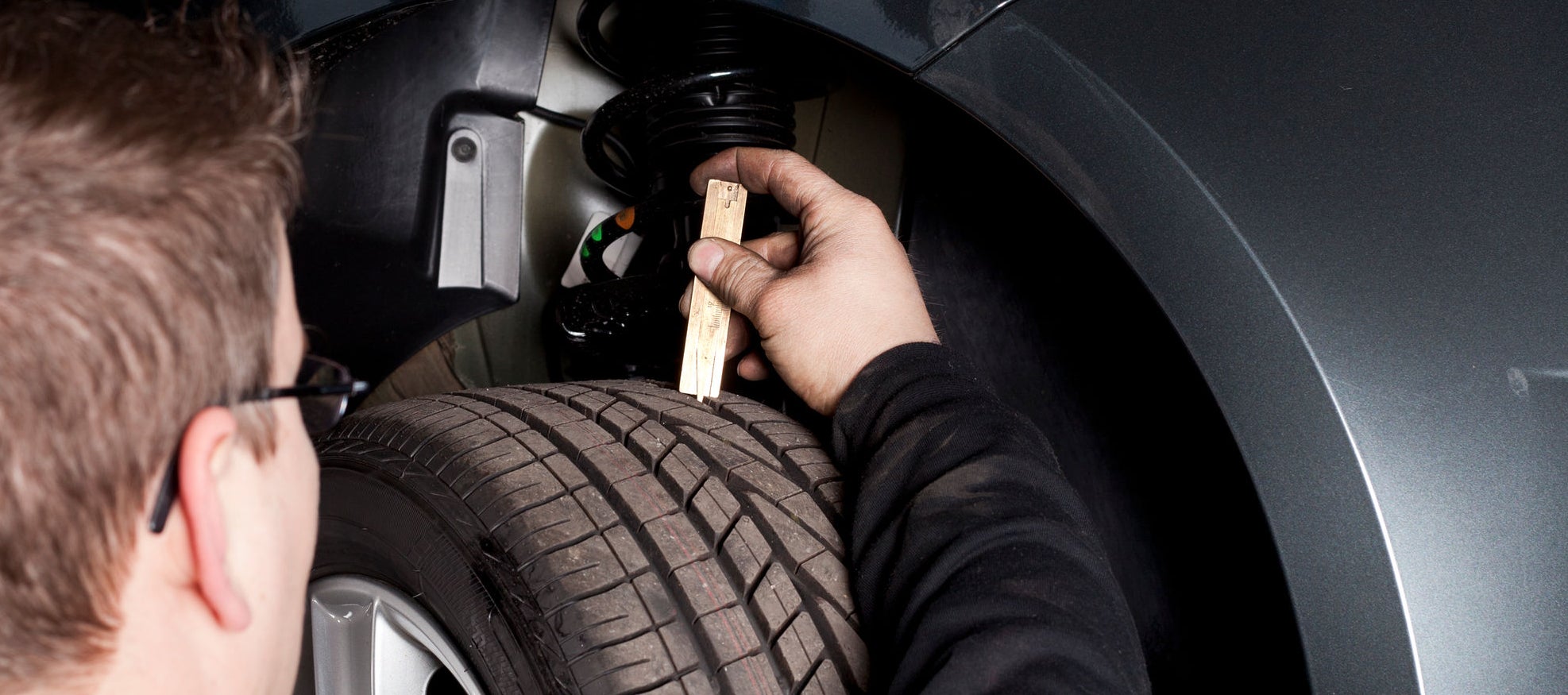 Mechanic is checking the skid depth/tread of a tire