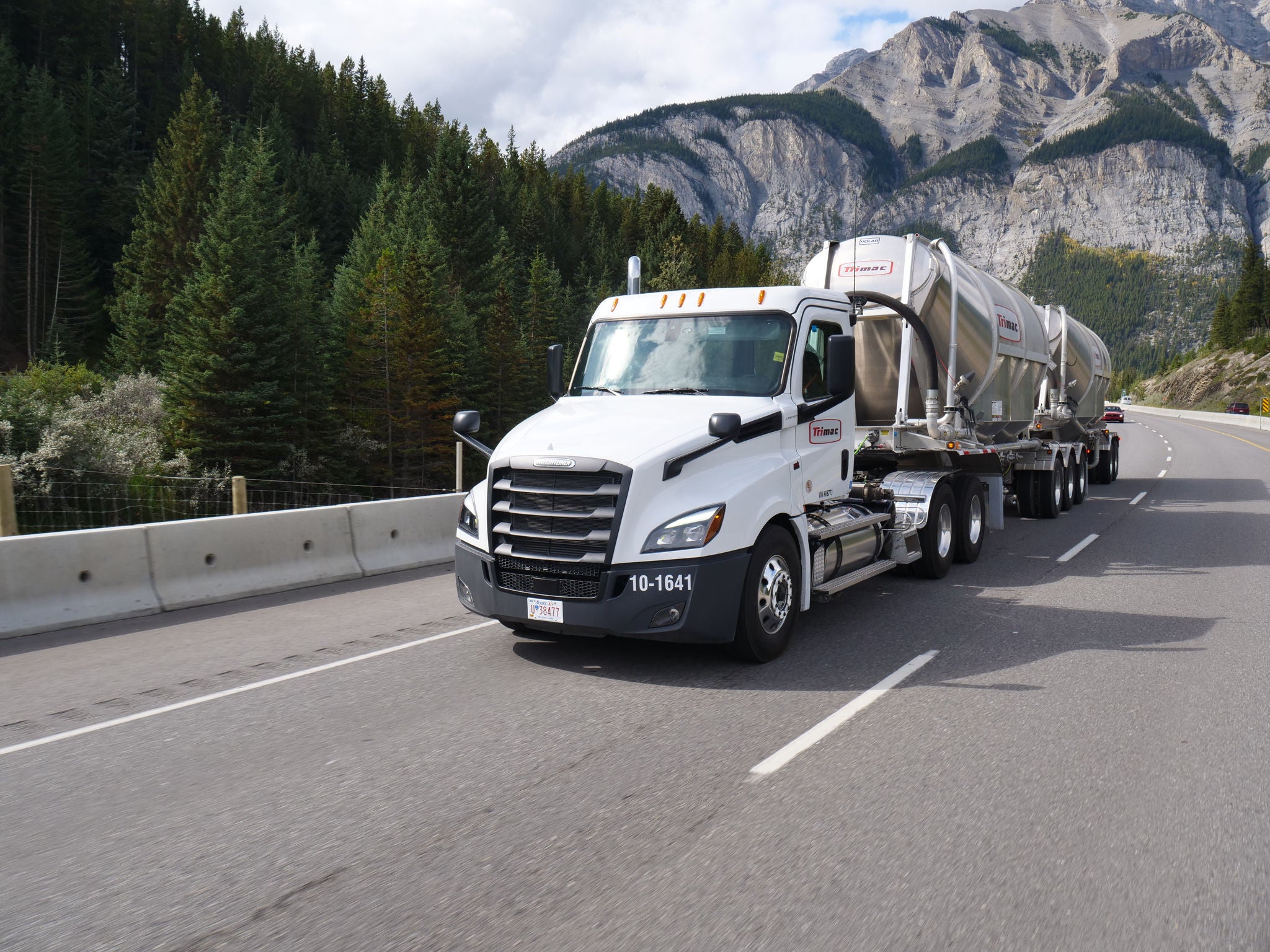 A photo of a Trimac Transportation liquid tanker driving on the highway.