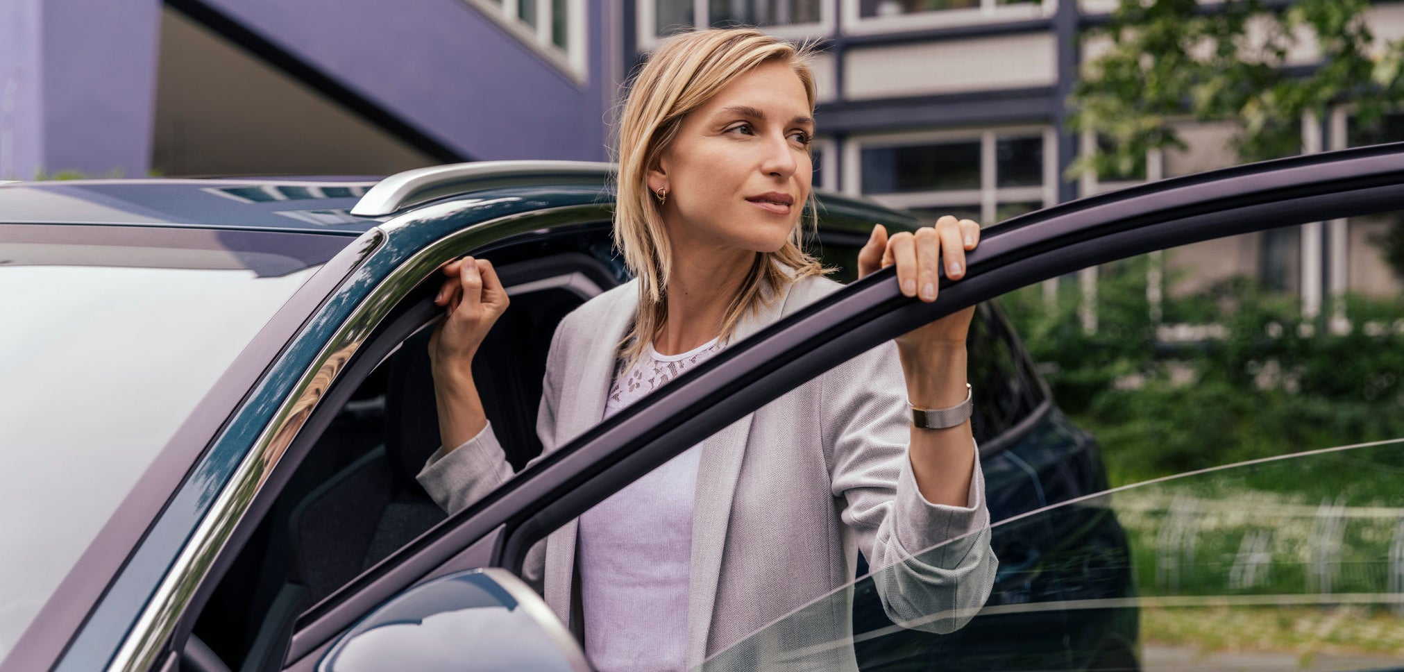 Woman leaning at open car door, Cologne, NRW, Germany